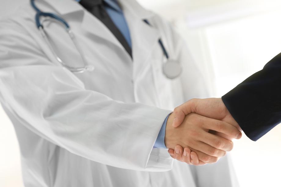 Doctor physician shaking hands with a financial adviser and financial planner. 